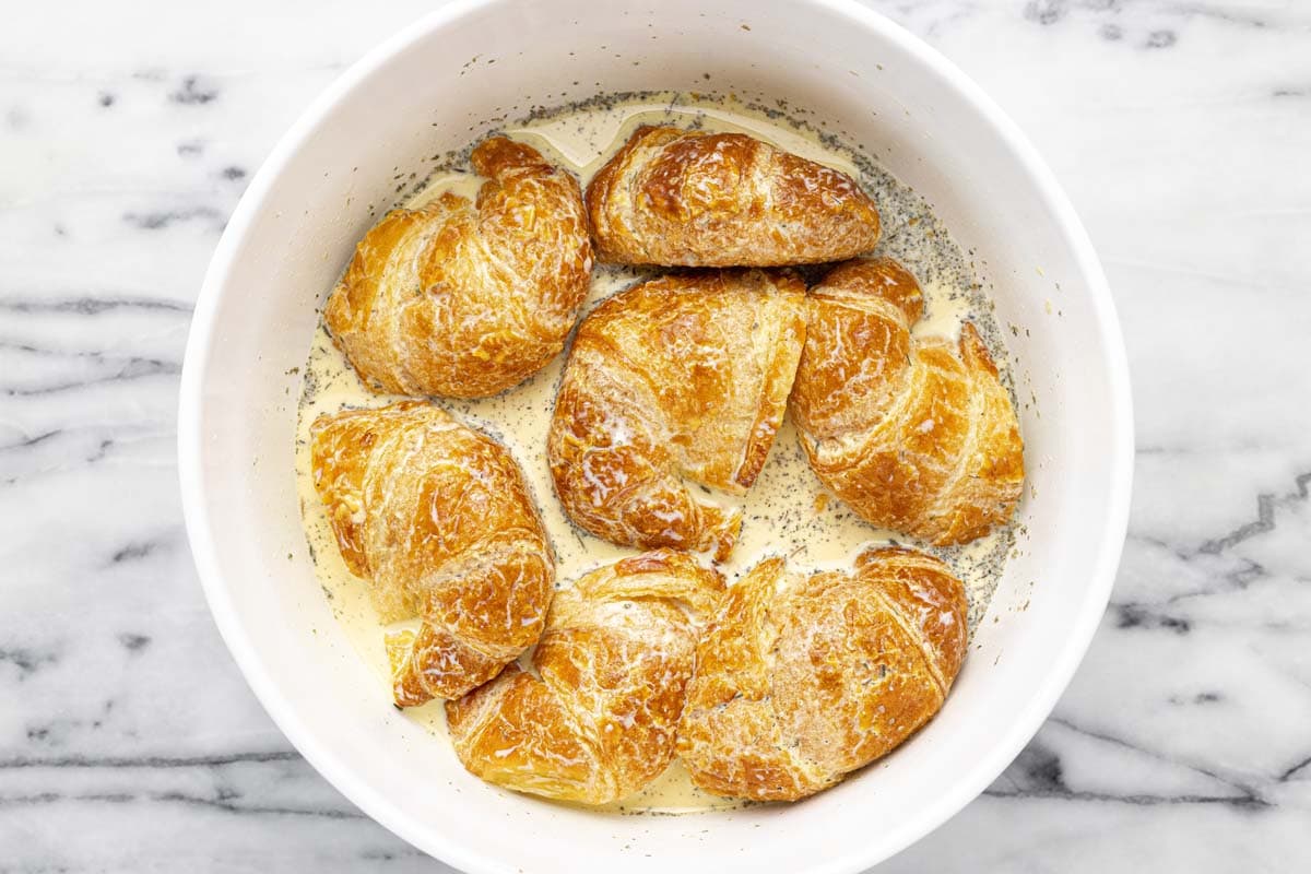 Croissants dipped in egg custard for an egg bake.