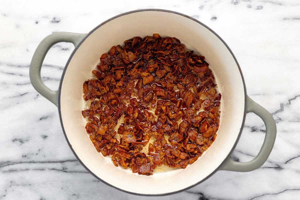 Crispy diced bacon in a large pot. 