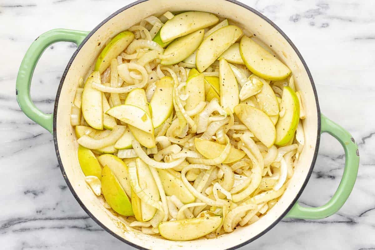 Sauteed onion and apple in a large pan. 