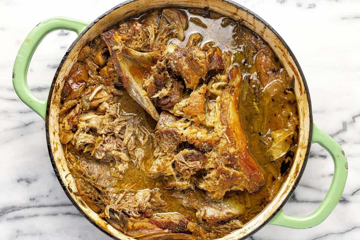 Braised pork in liquid in a large saute pan. 