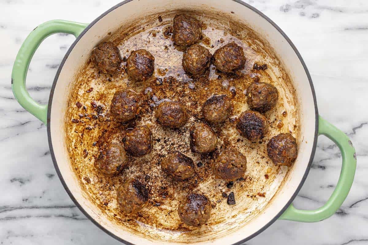 Pan seared French onion meatballs in a large pan.