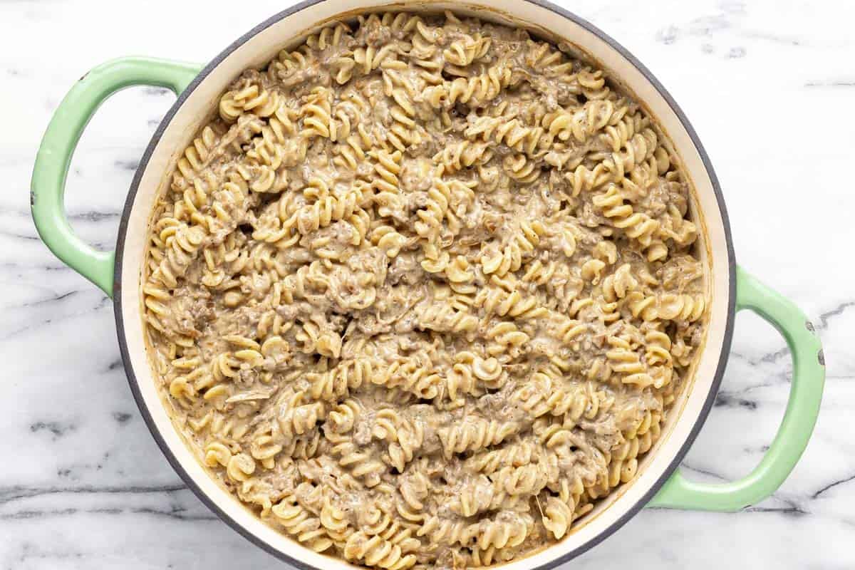 Creamy French onion pasta with ground beef in a large pan.