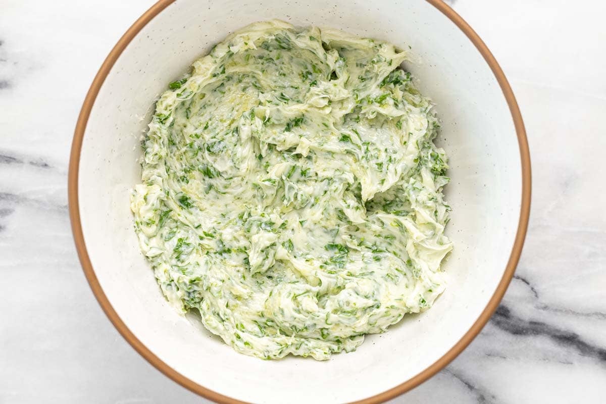 Bowl of homemade garlic butter with parsley.