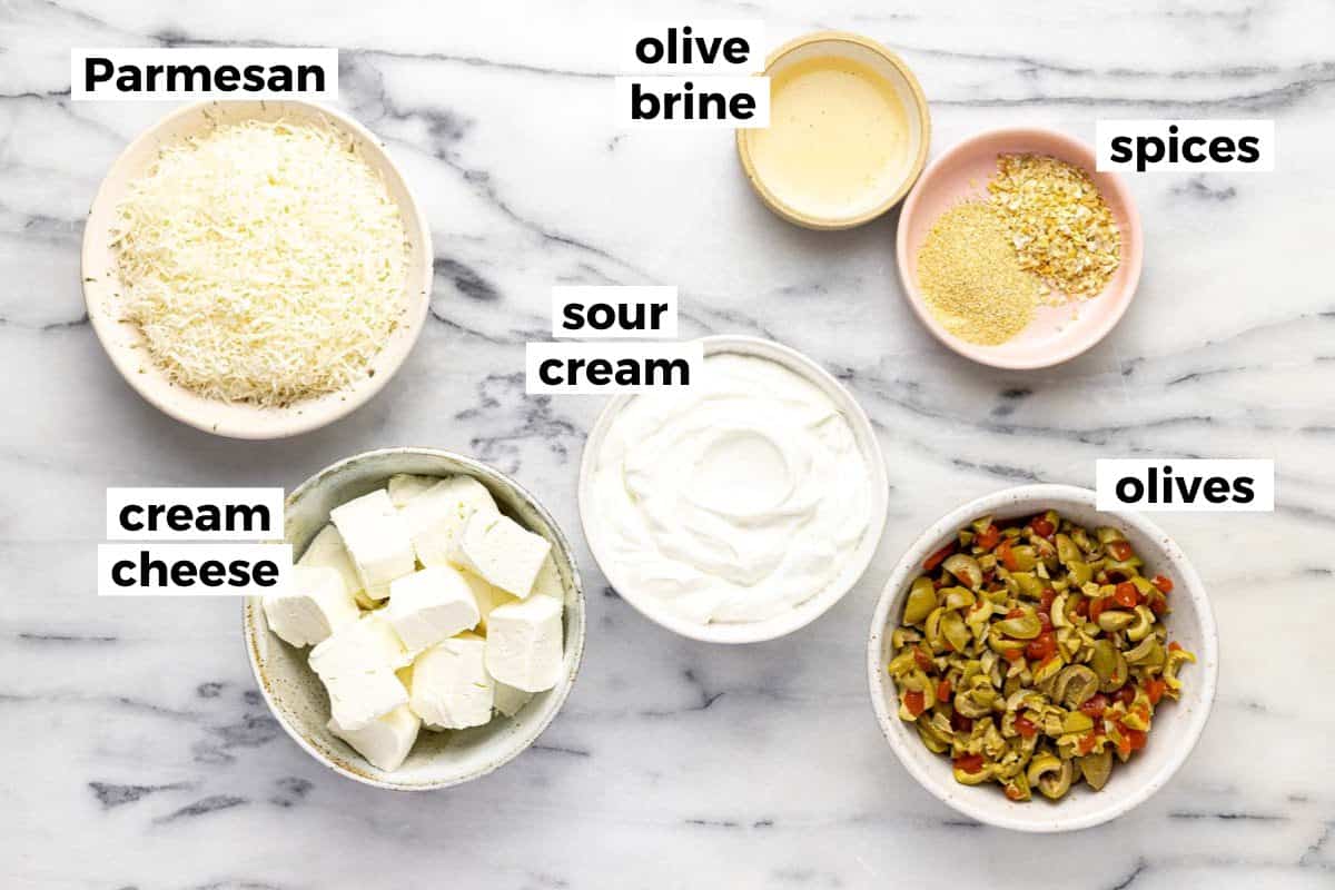 Bowls of ingredients to make cold olive dip. 