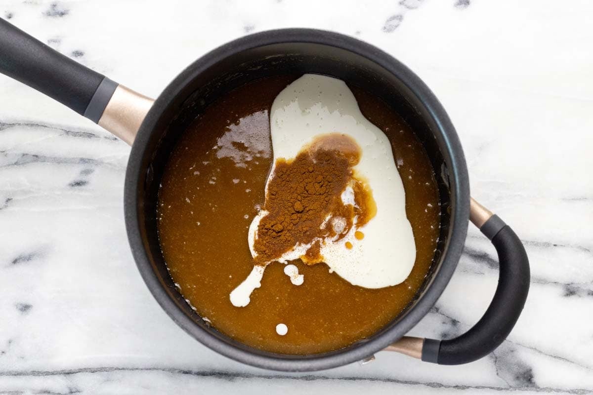 Small saucepan with caramel sauce, heavy cream, and cinnamon.