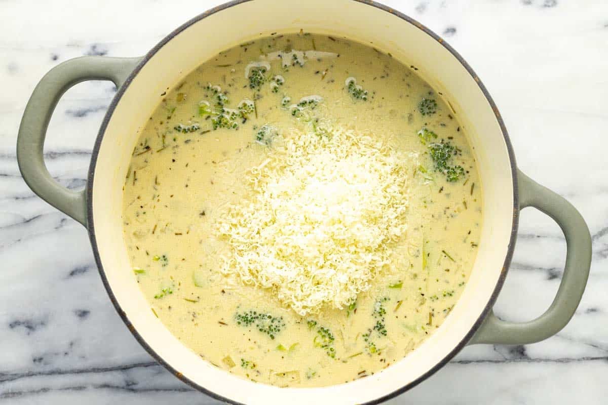 Freshy grated Parmesan added to a pot of creamy soup.
