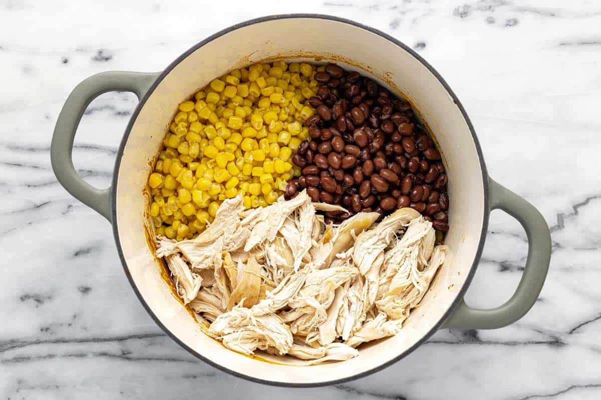 Corn, black beans, and chicken in a large soup pot.