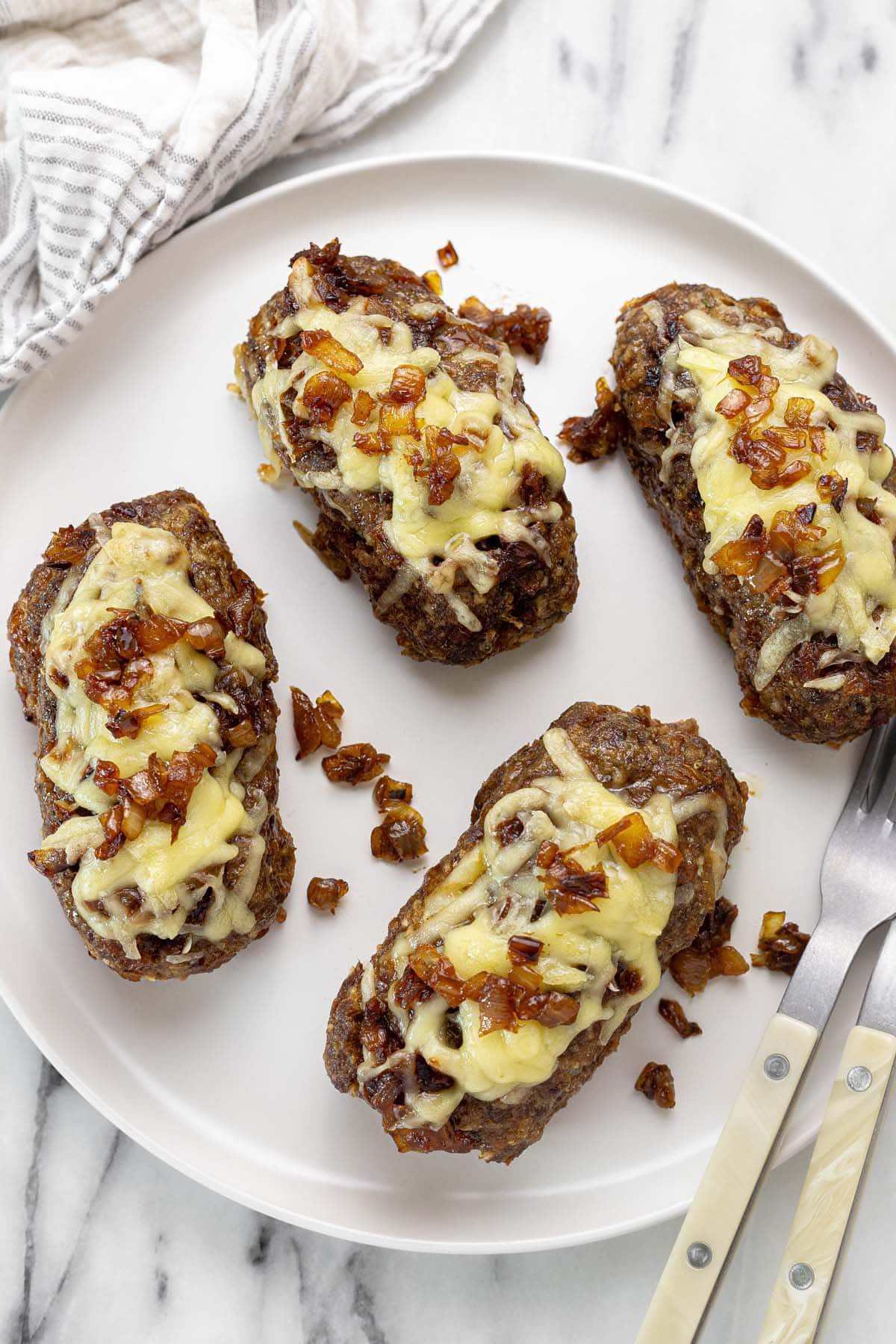 Plate with four mini French onion meatloaves.