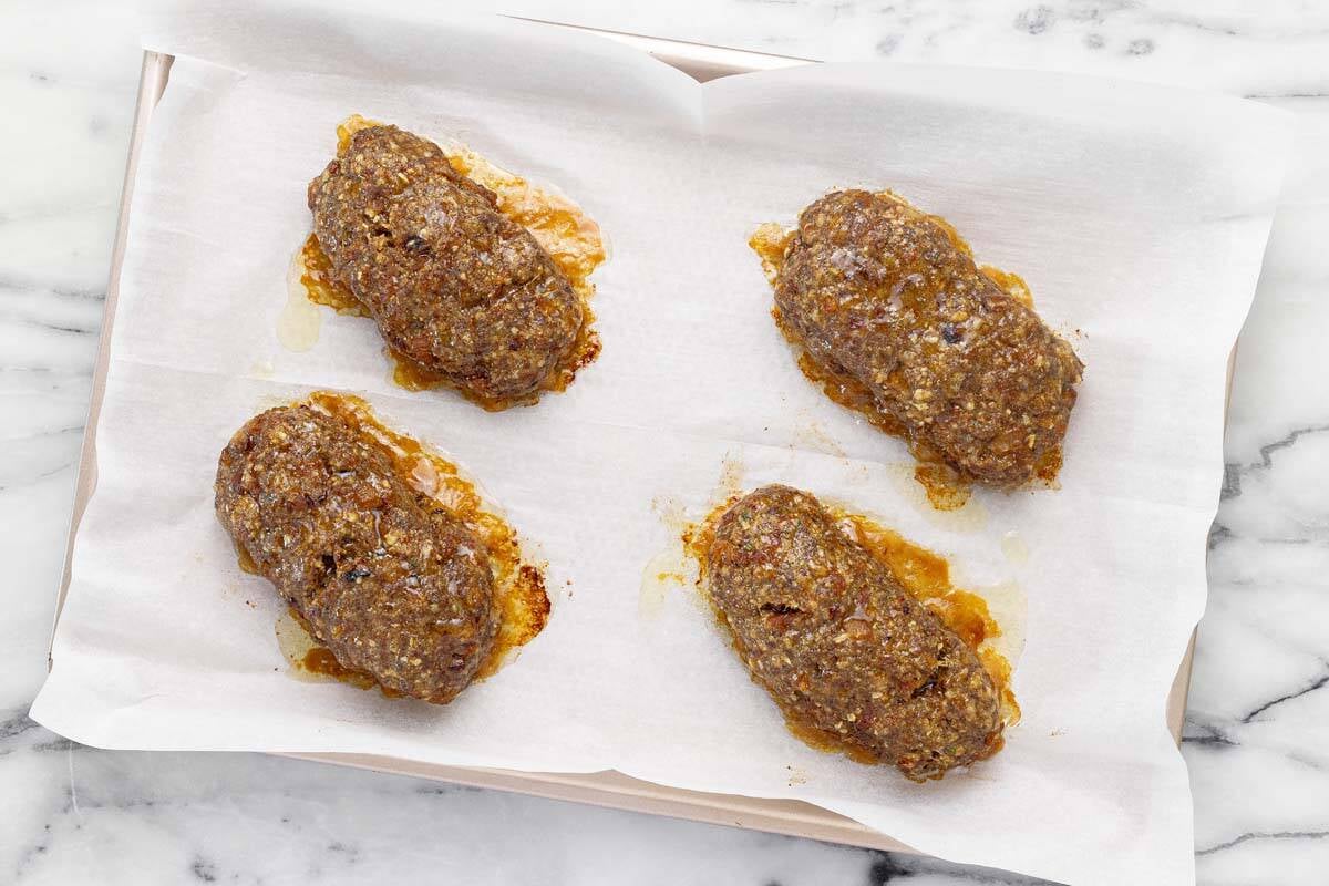Baked mini meatloaf on a sheet pan.