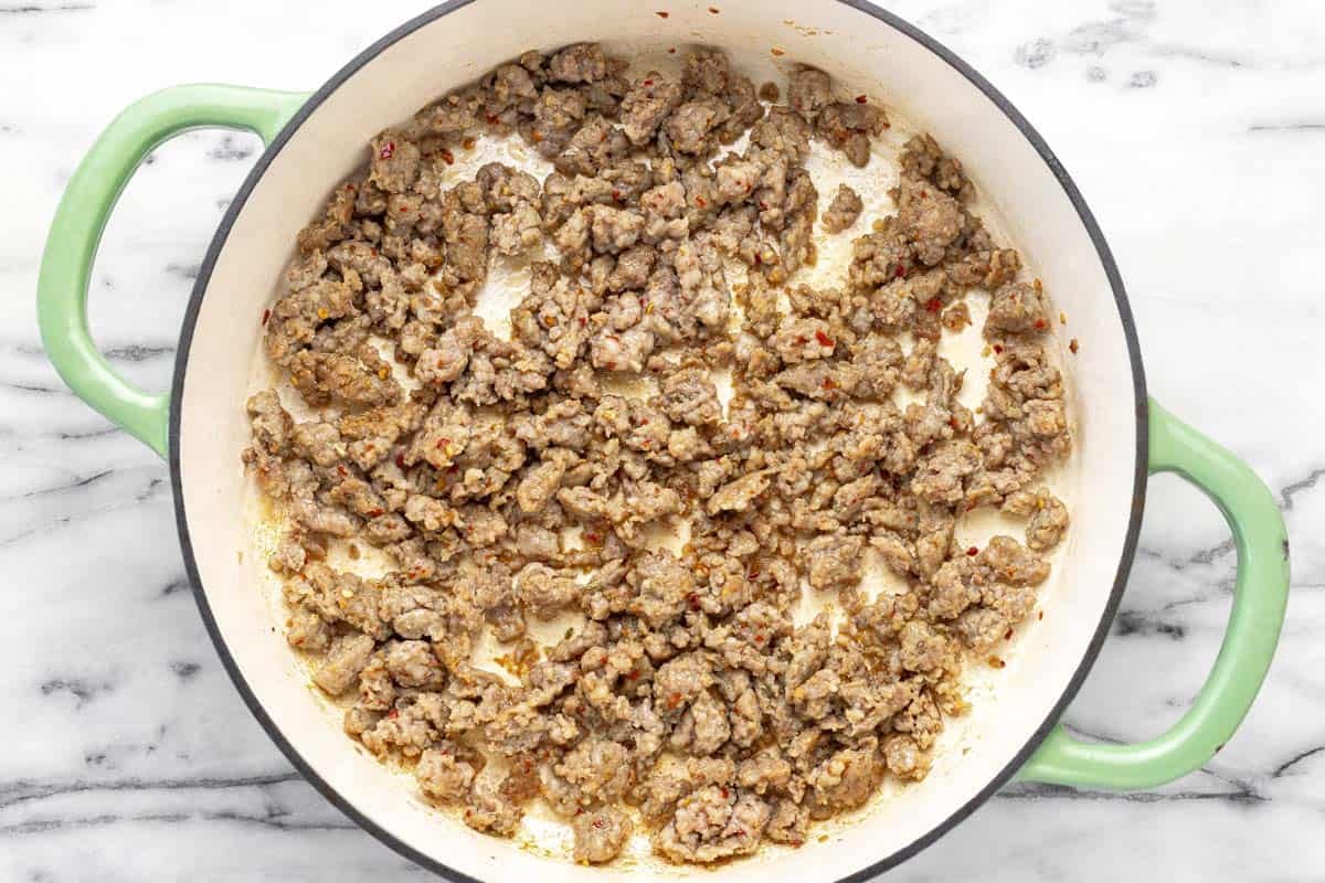 Browned sausage in a large pan.