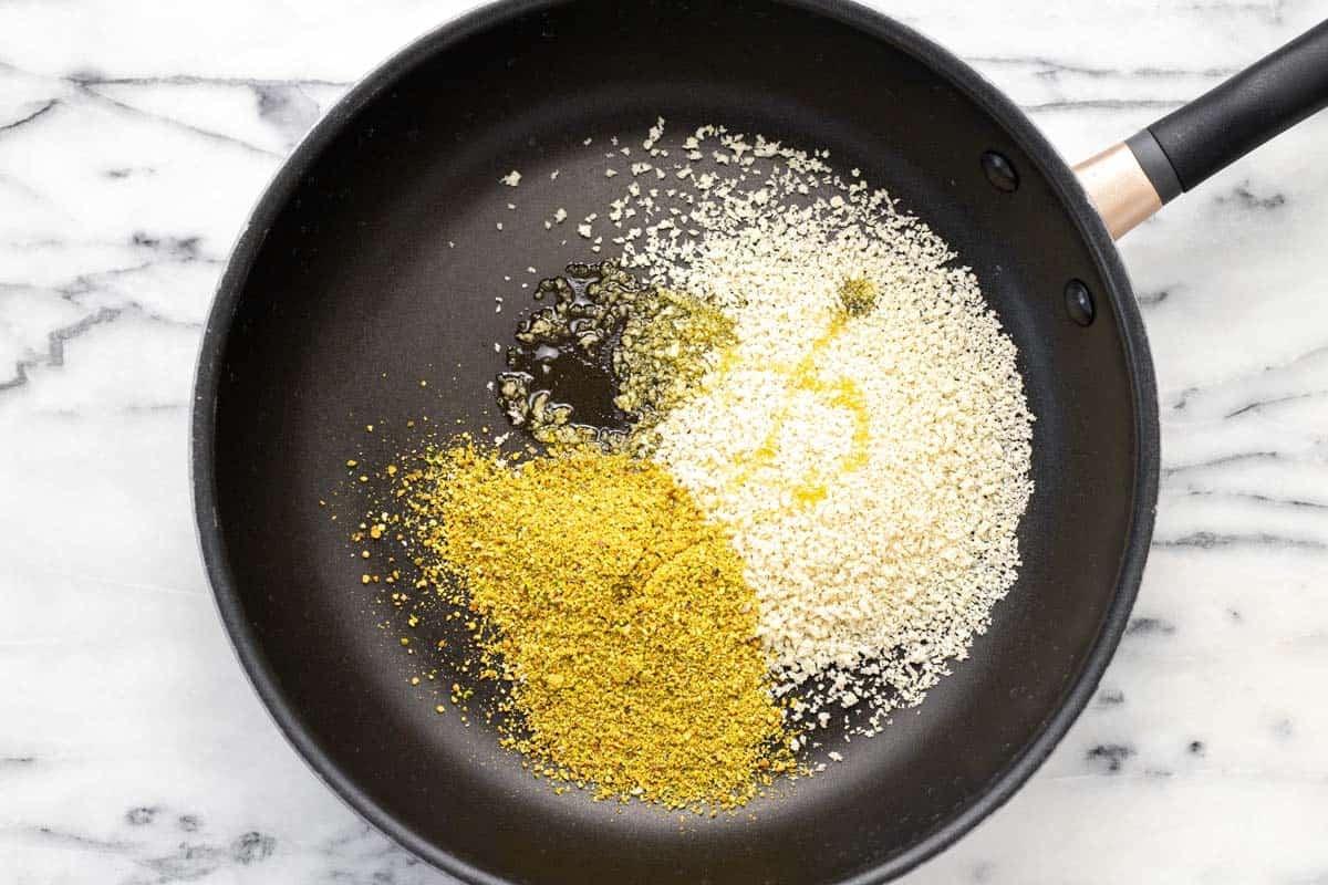 Large pan with Panko breadcrumbs, pistachios, and olive oil.