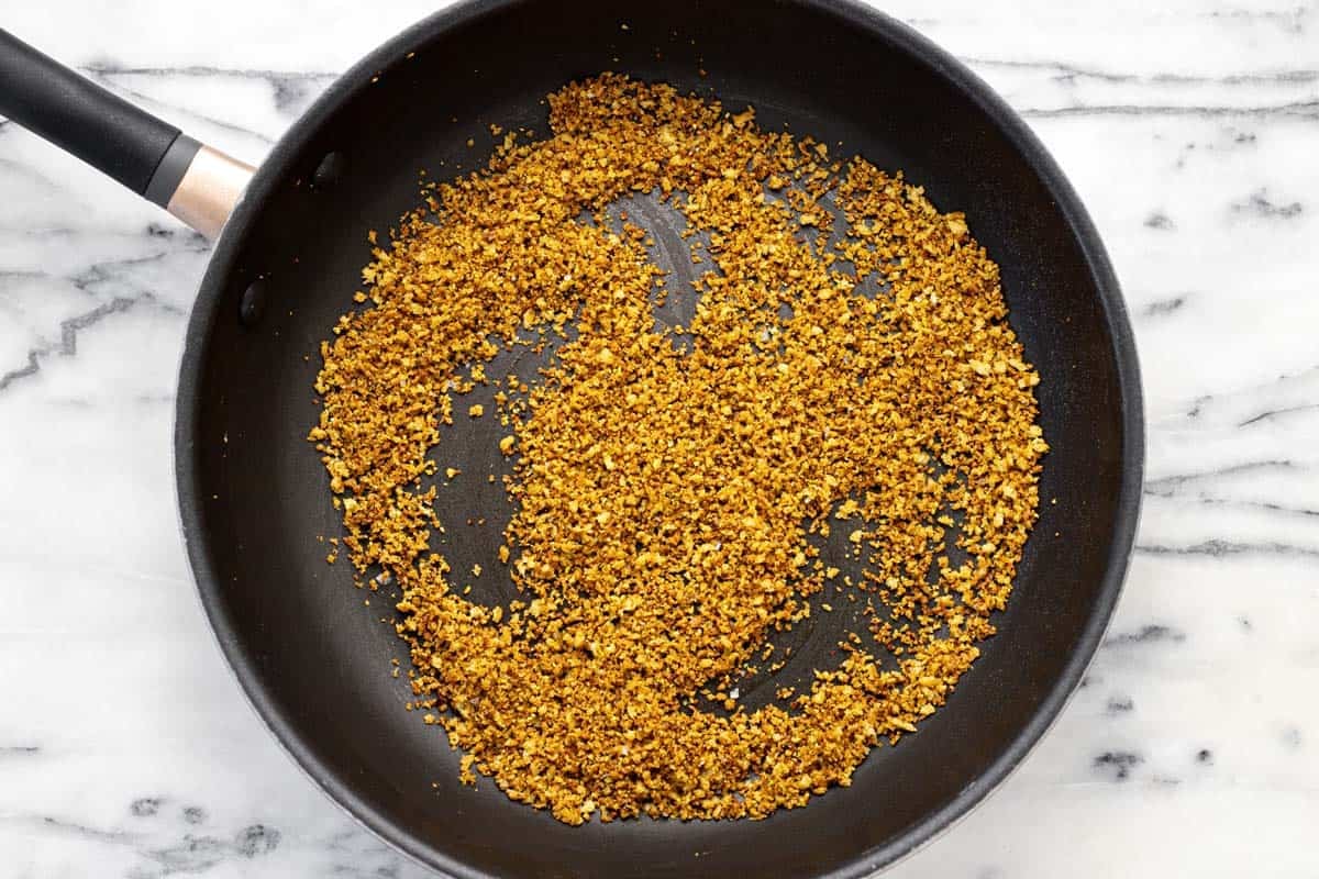 Toasted breadcrumbs and pistachios in a large pan.