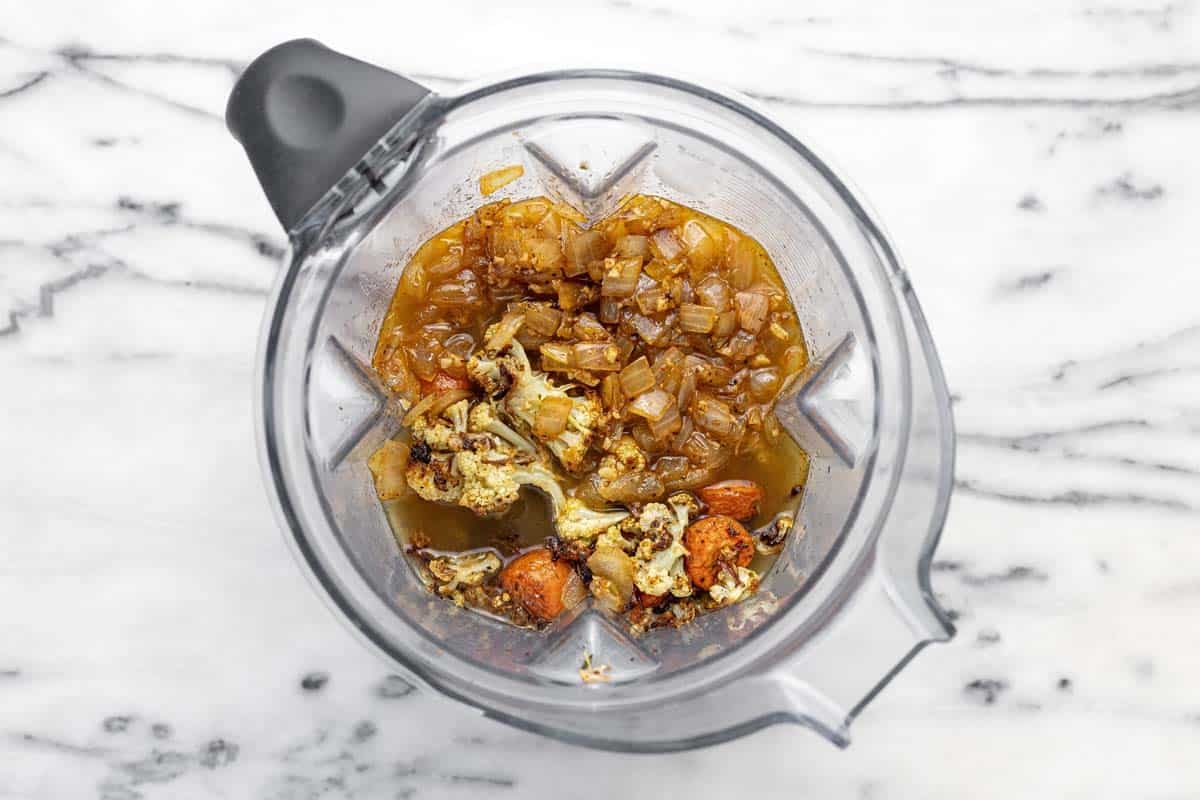 Blender filled with sauteed veggies, roasted veggies, and stock.