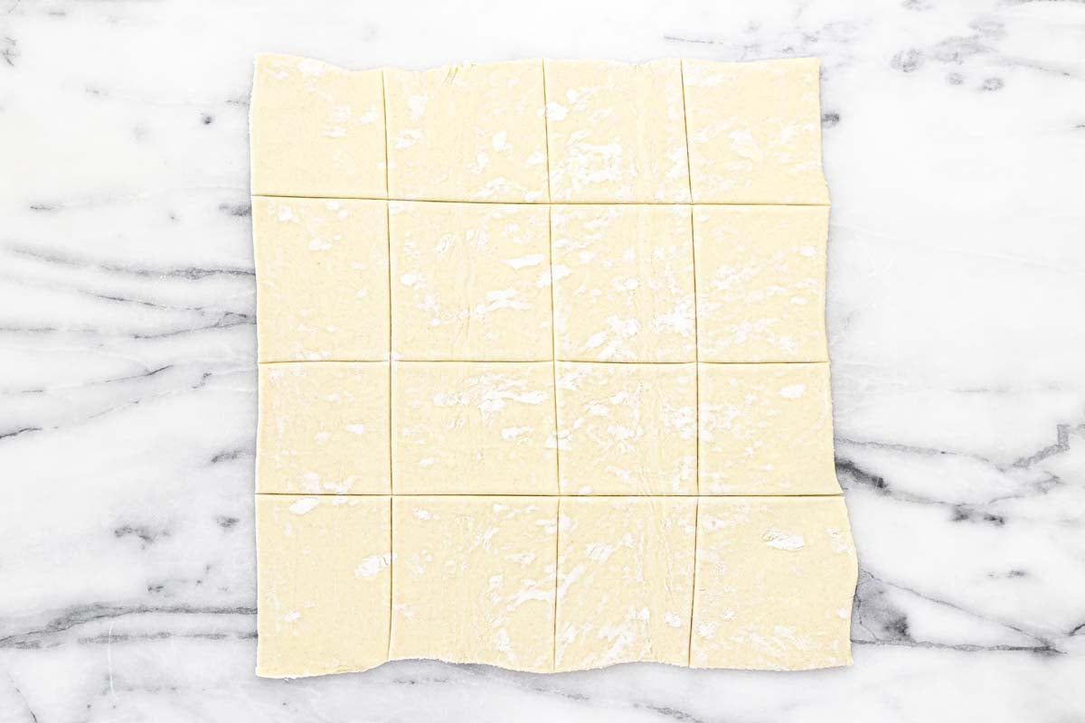 Puff pastry sheet sliced into squares.