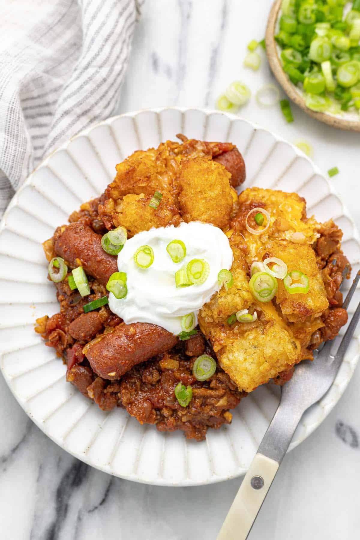 Plate filled with a serving of chili cheese dog tater tot casserole.