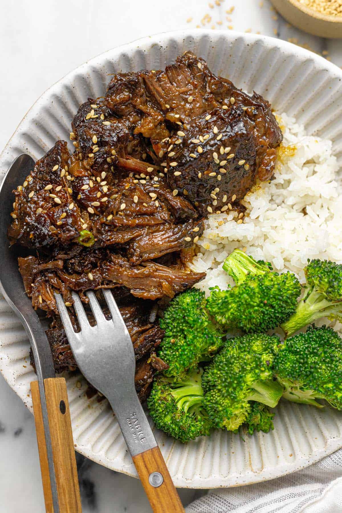 Bowl of shredded sesame braised beef, rice, and broccoli.