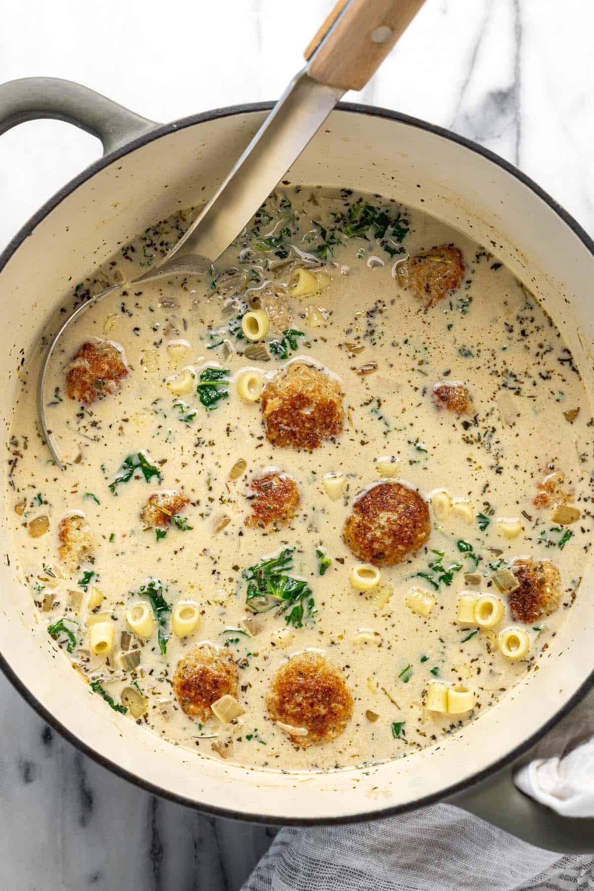 Large pot filled with creamy chicken noodle meatball soup.