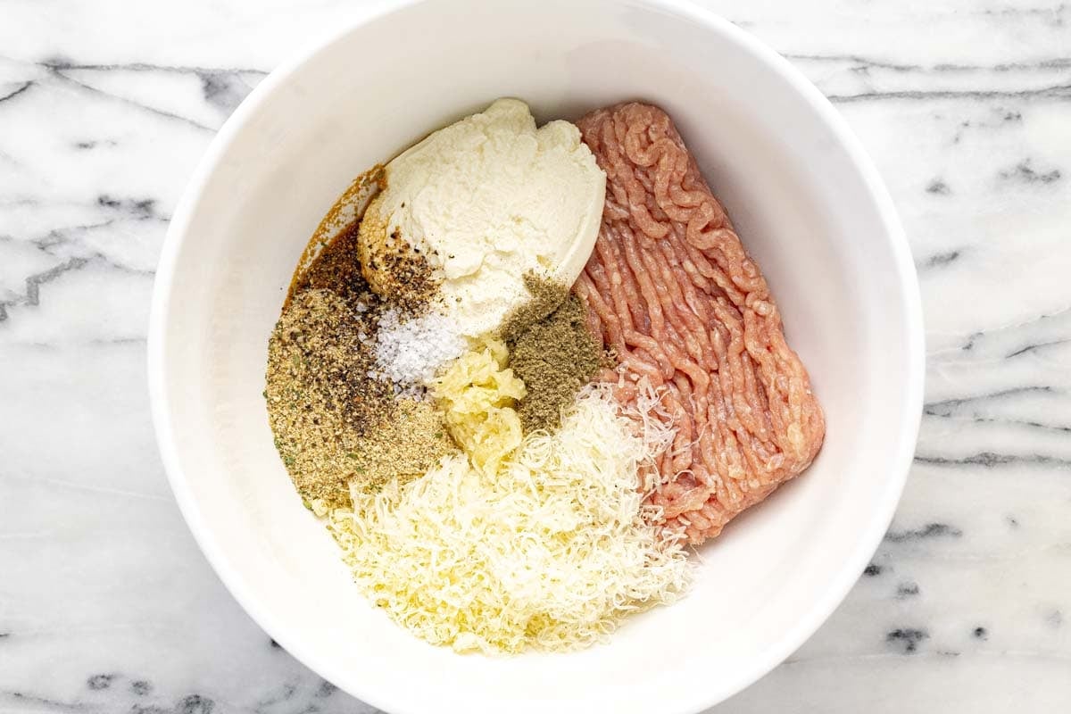 Bowl filled with ingredients to make chicken meatballs.