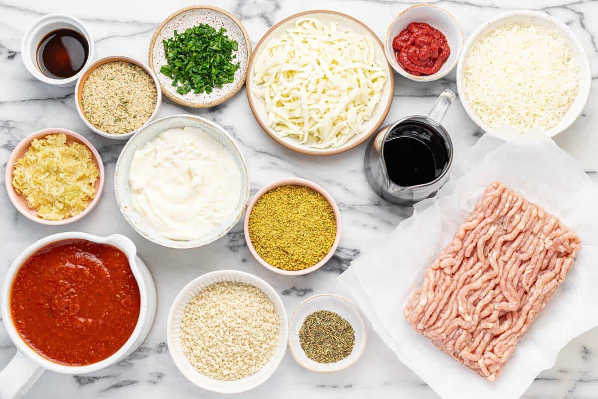 Bowls of ingredients to make chicken Parmesan meatballs.