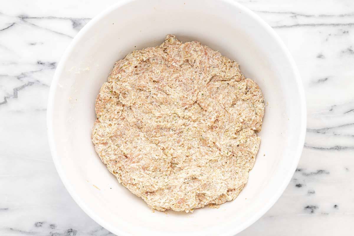 Large bowl filled with chicken meatball mixture.