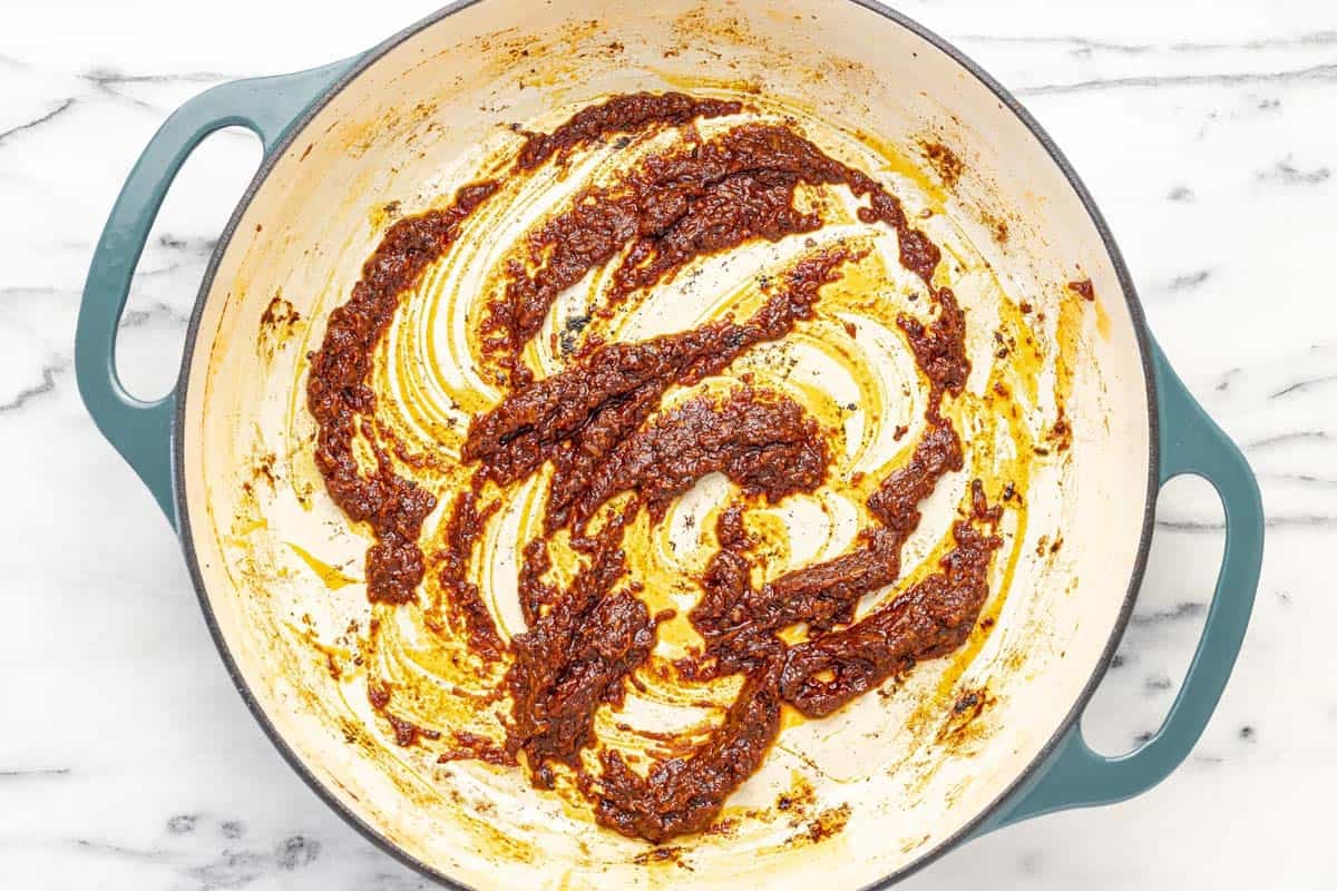 Garlic, tomato paste, and reduced red wine in a large pot.