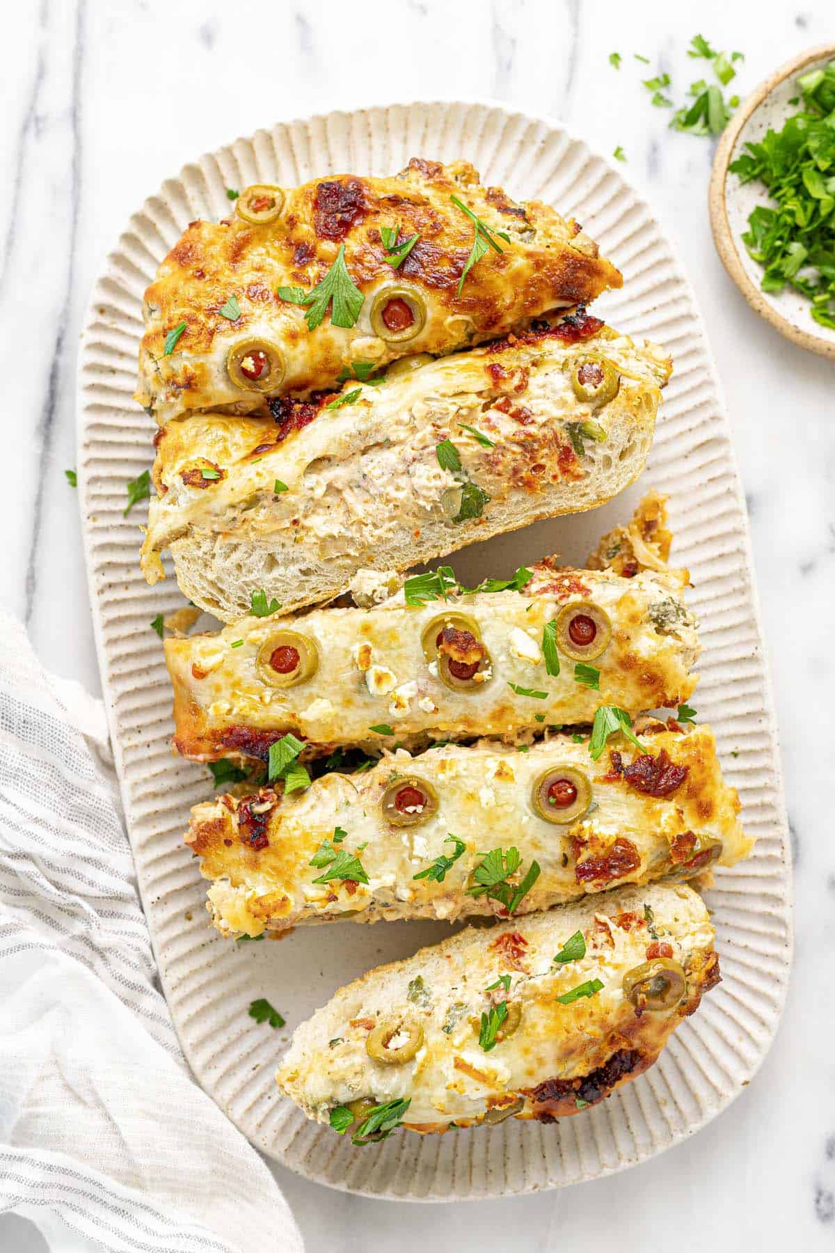 Serving platter with sliced Greek garlic cheese bread on it. 