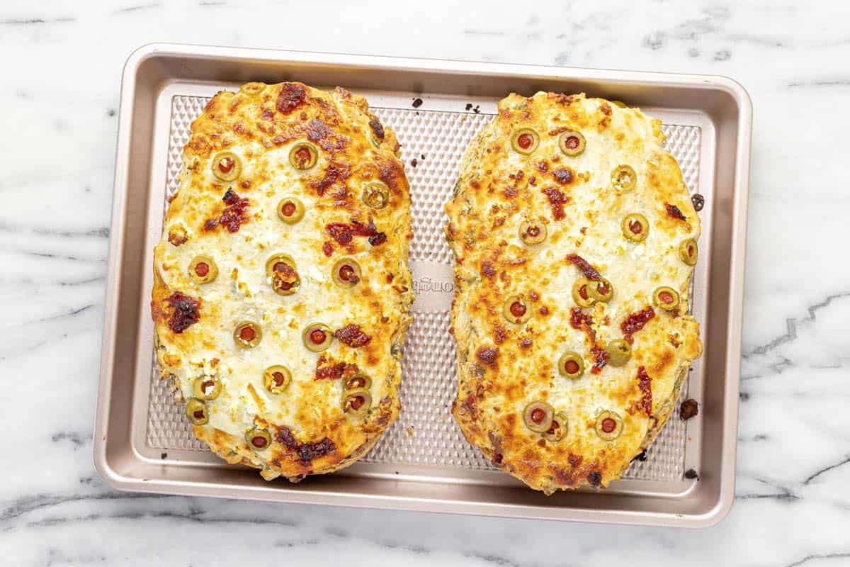 Freshly baked Greek garlic cheese bread on a sheet pan.