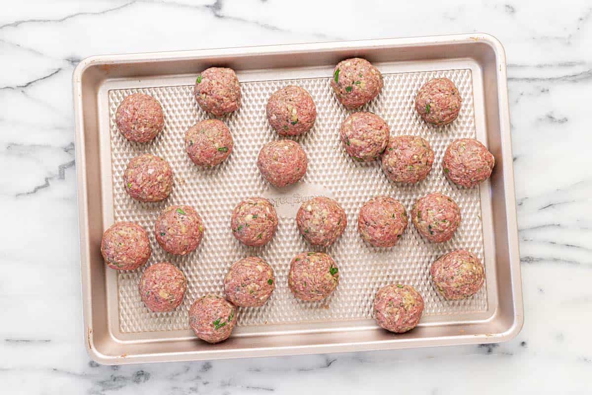 Homemade meatballs on a baking sheet.