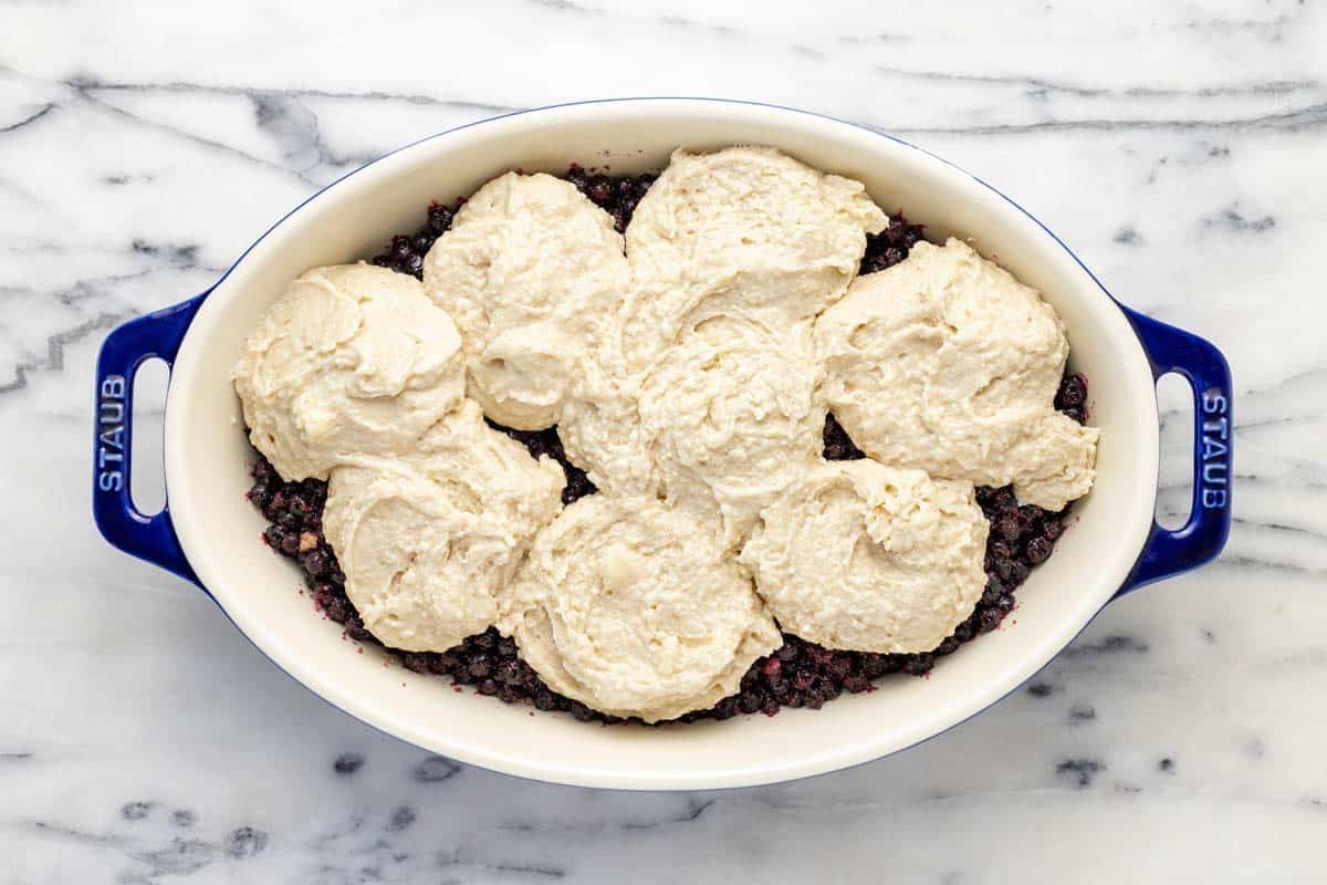 Homemade blueberry cobbler in a baking dish just before going in the oven.
