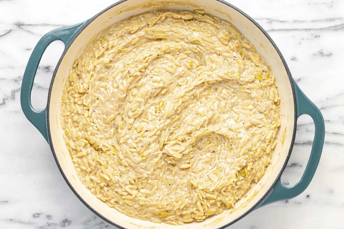 Cheesy orzo pasta in a large pan.