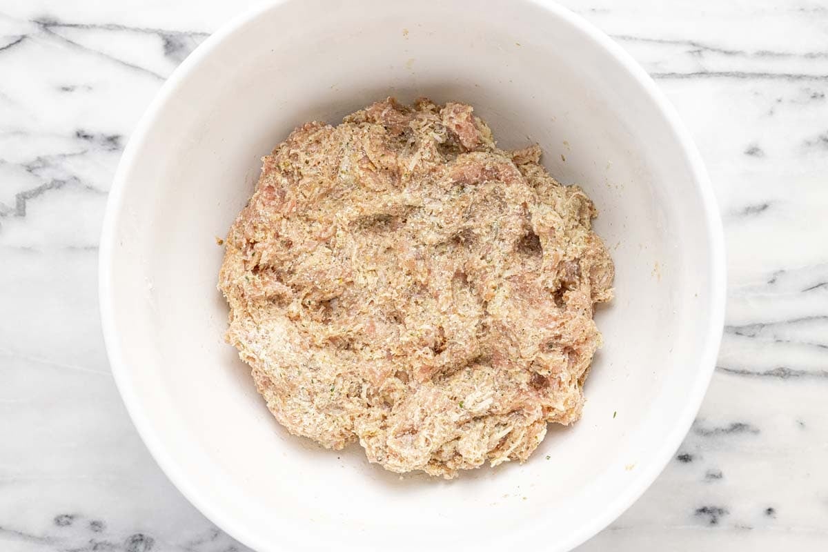 Large bowl filled with chicken meatball mixture.