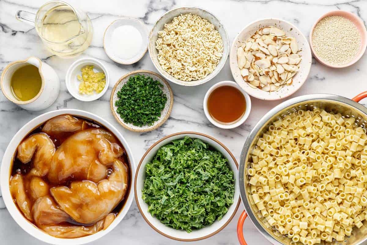 Bowls of ingredients to make sesame chicken pasta salad.