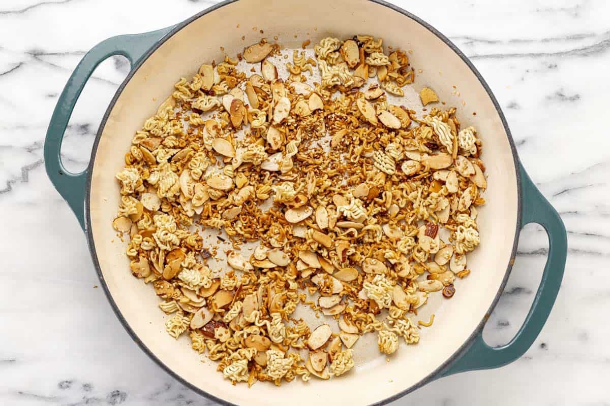 Large pan filled with crispy ramen, almonds, and sesame seeds.