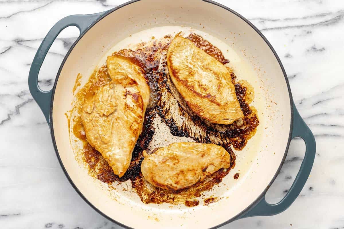 Cooked chicken breast in a large pan.