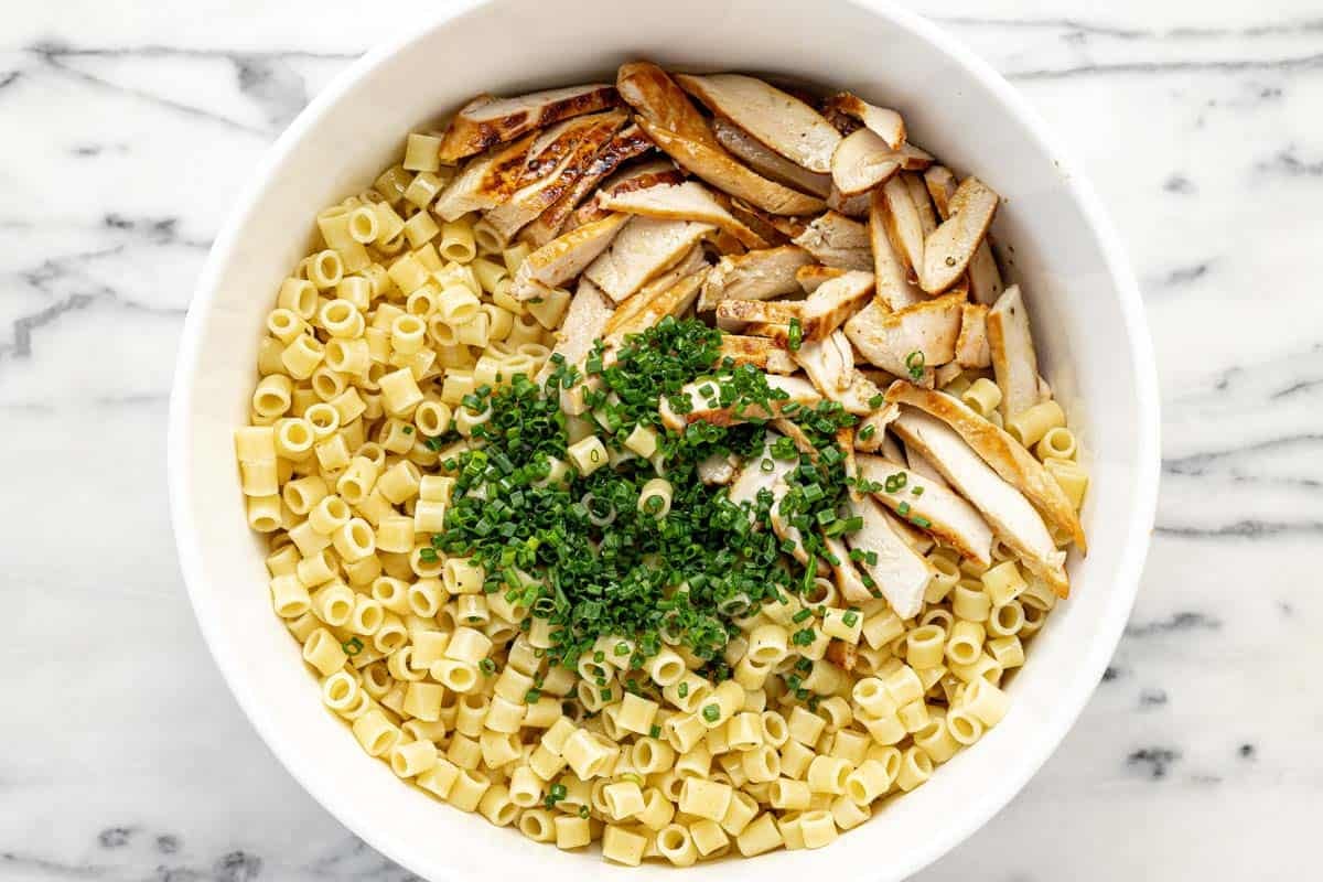 Bowl filled with ingredients to make sesame chicken pasta salad.