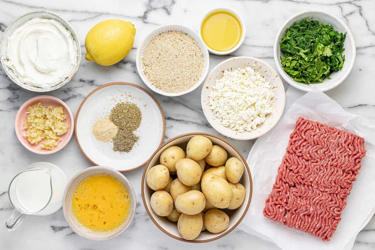 Bowls of ingredients to make sheet pan feta meatballs and potatoes.