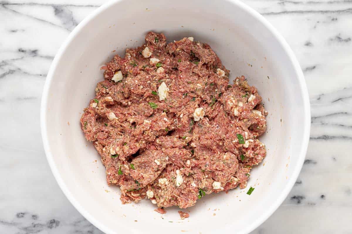 Bowl filled with Greek meatball mixture.