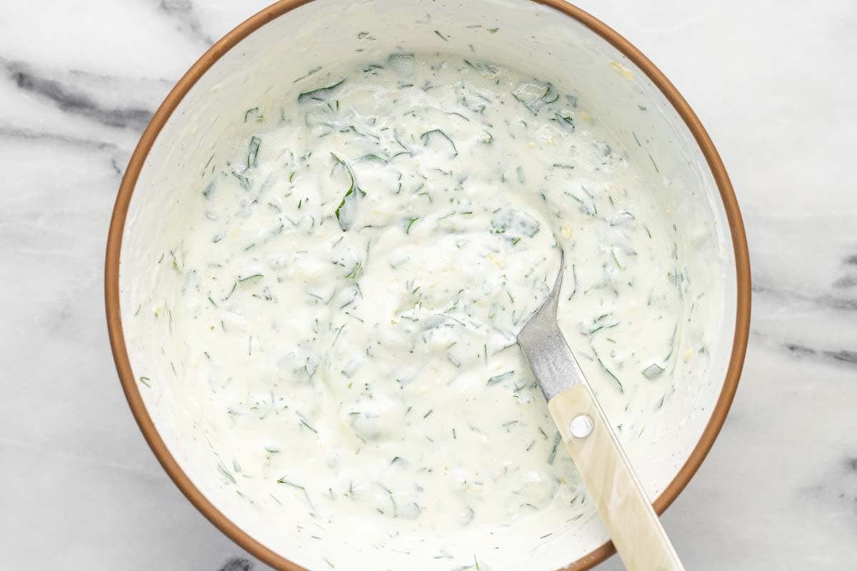 Bowl filled with creamy dill yogurt sauce.
