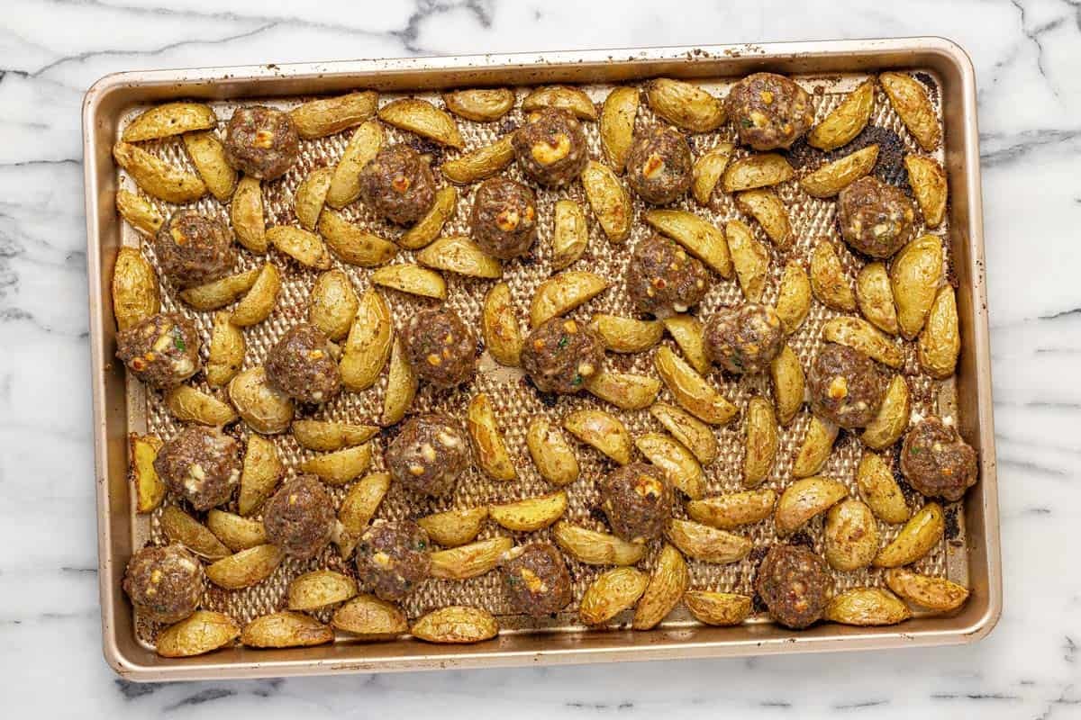 Sheet pan with roasted potatoes and Greek meatballs.