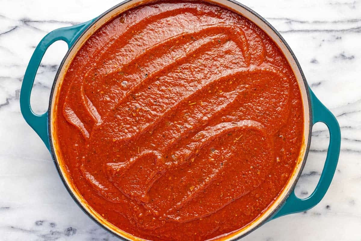 Large pan filled with homemade tomato sauce for meatballs.