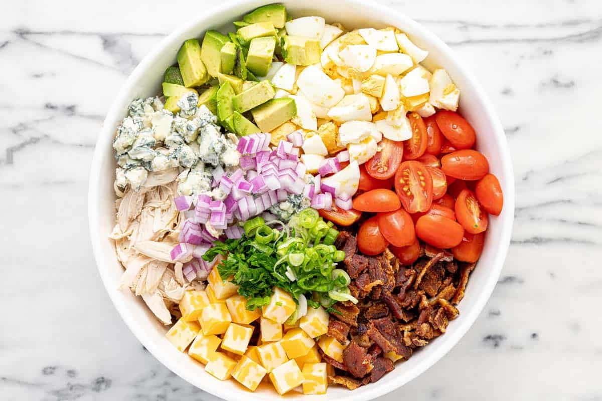 Large bowl filled with cobb pasta salad ingredients.