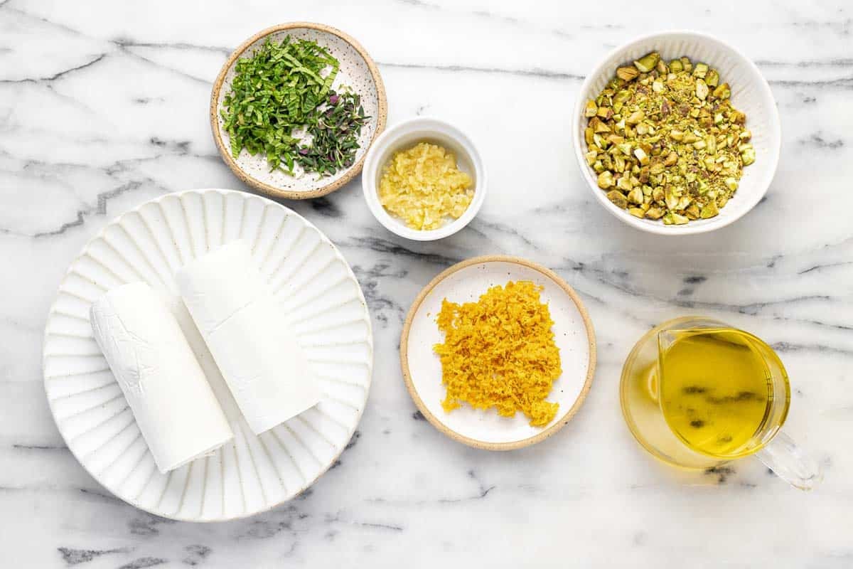 Bowls of ingredients to make marinated goat cheese.
