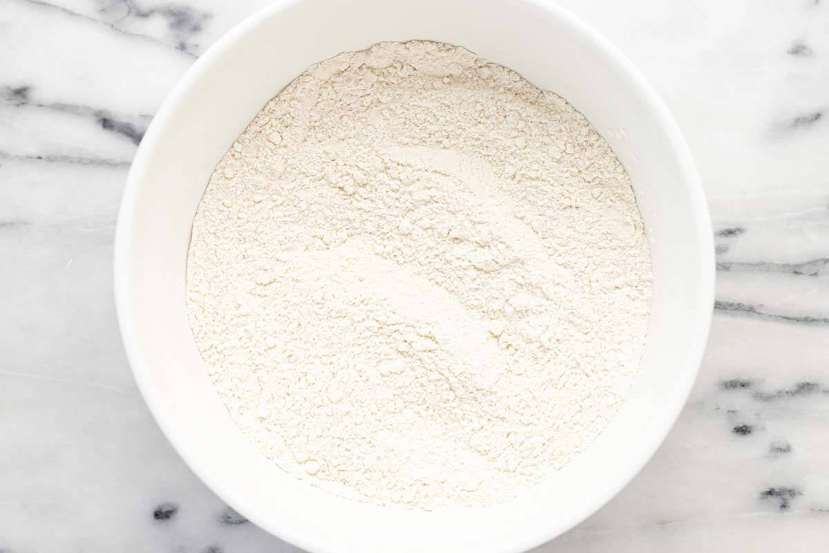 Bowl filled with flour and other ingredients for the cobbler base.