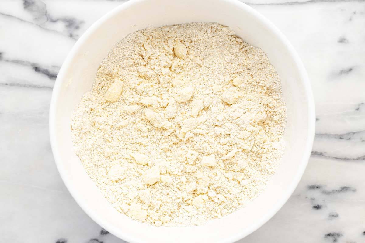 Pea size bits of butter in a bowl of flour and other ingredients.