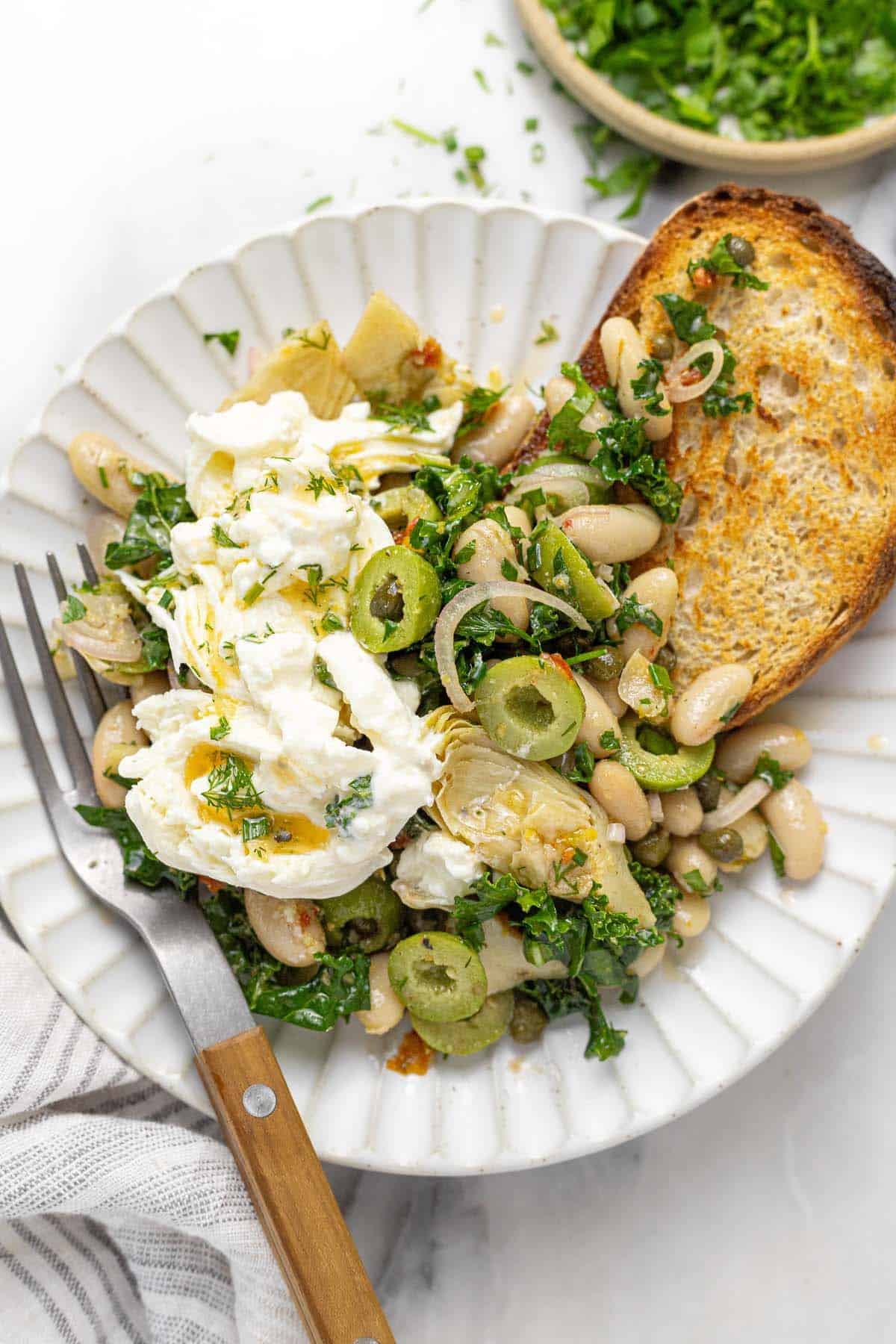 Plate filled with white bean salad topped with burrata.