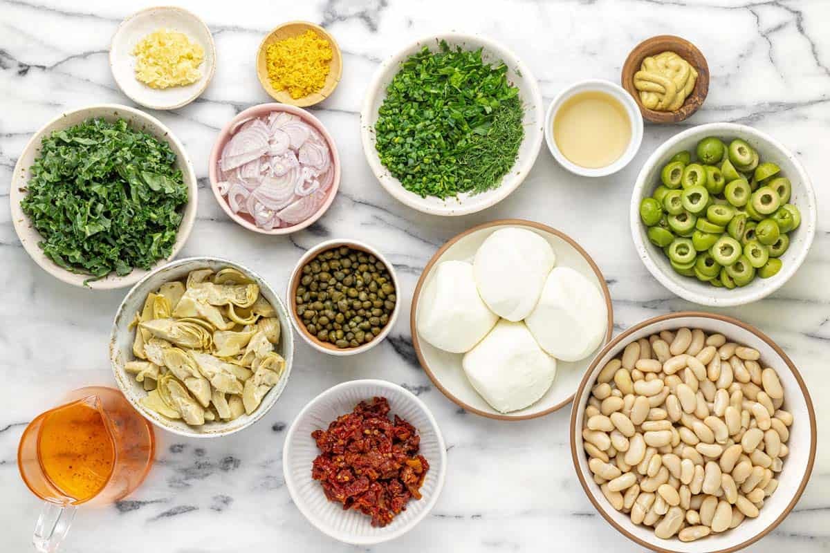 Bowls of ingredients to make white bean salad.