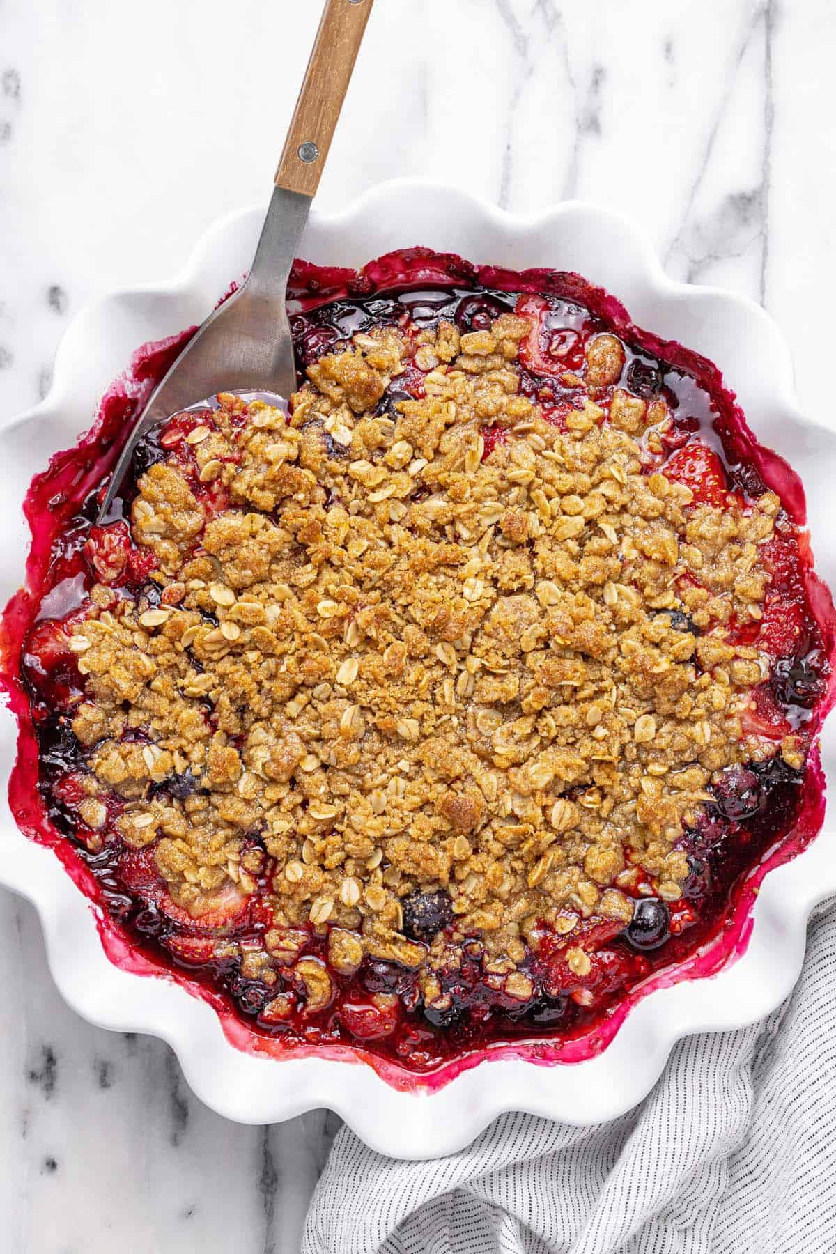 Large pie dish filled with homemade berry crisp.