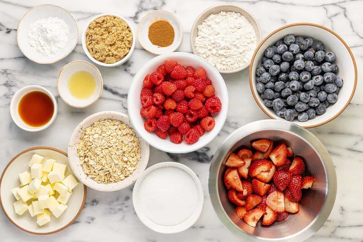 Bowls of ingredients to make homemade triple berry crisp.
