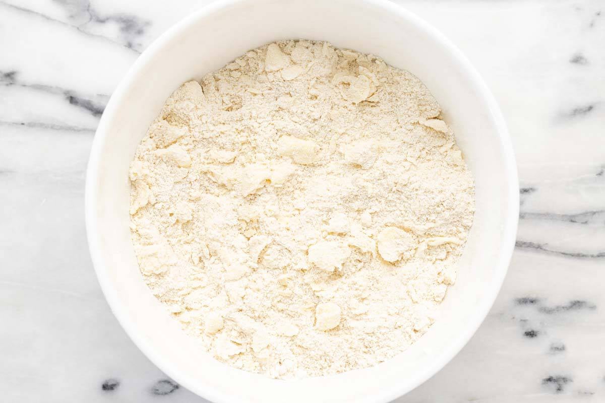 Cold butter cut into a bowl of dry ingredients in a large bowl.