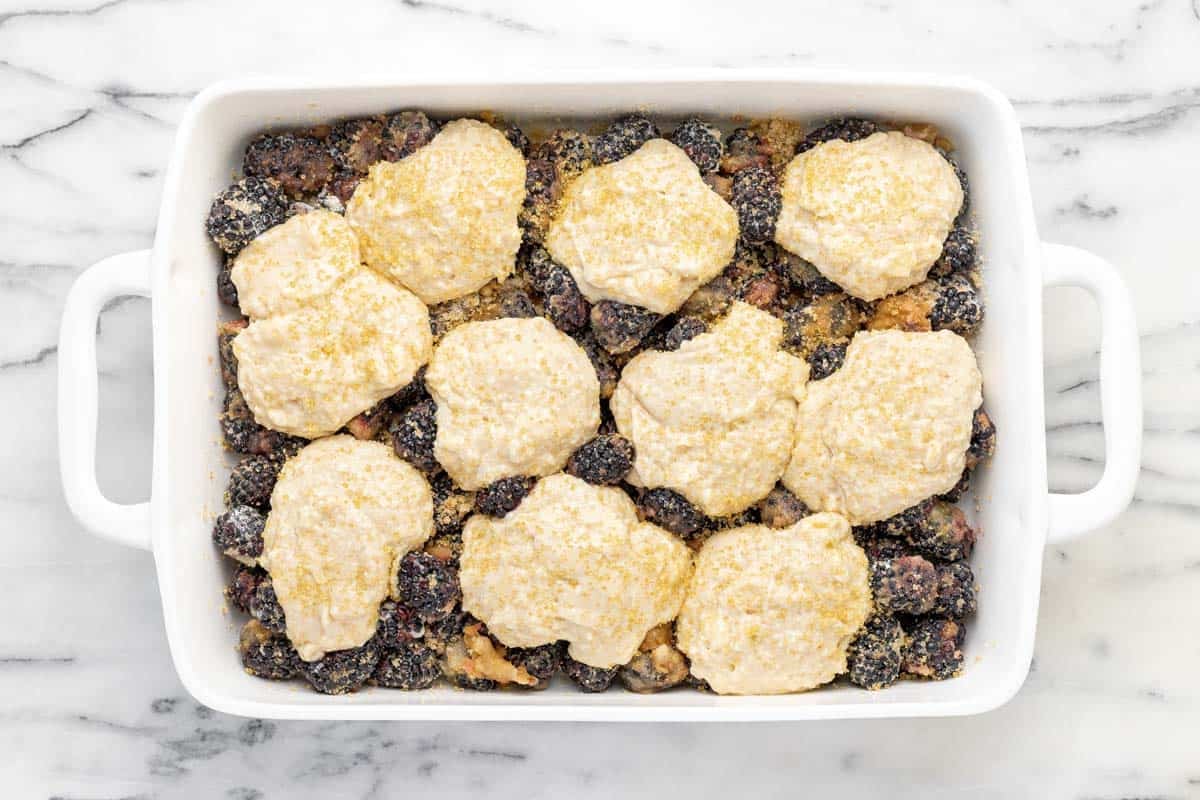 Baking dish filled with blackberry cobbler ready to go in the oven.